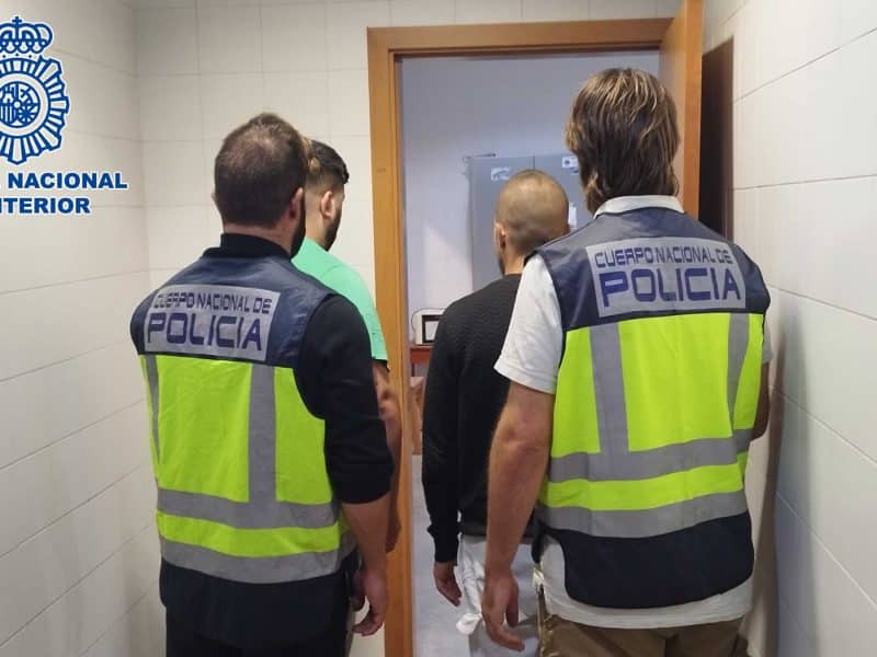 Los detenidos escoltados por dos agentes de policía