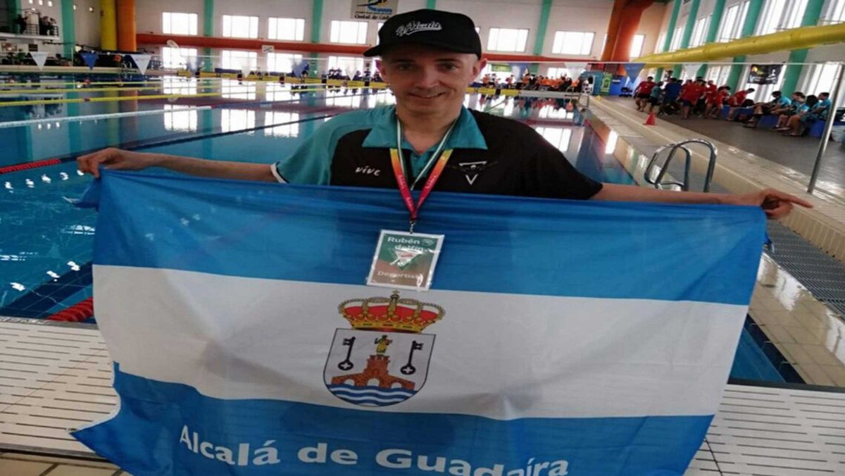 Rubén Darío Herrera posa con la bandera alcalareña junto a la piscina