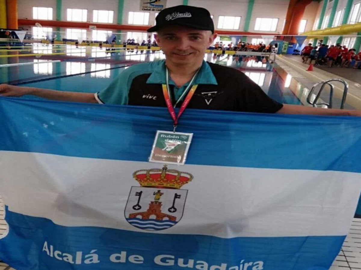 Rubén Darío Herrera posa con la bandera alcalareña junto a la piscina